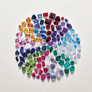 Several different coloured gemstones arranged together in a circle, making a wheel design.