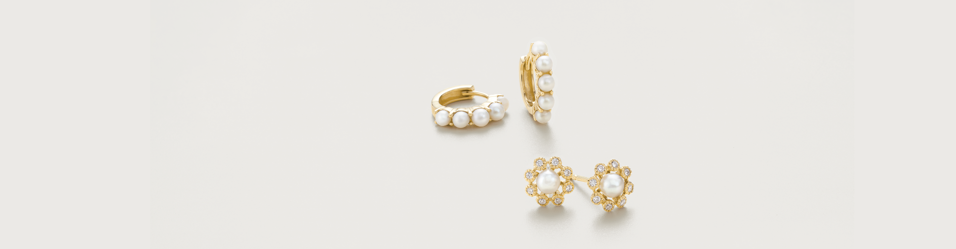 Pair of pearl hoop earrings, along with pearl and diamond floral stud earrings in yellow gold.